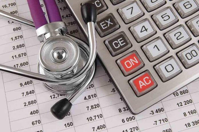 A stethoscope resting on a calculator and financial data sheets