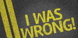 Bold yellow text on a dark asphalt surface stating I WAS WRONG