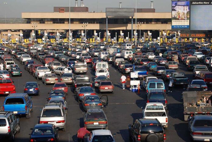 A crowded parking lot filled with cars near a border crossing