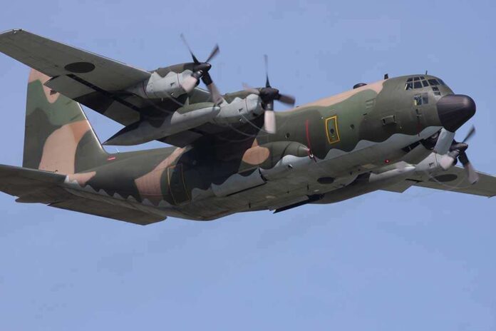Military C-130 Hercules aircraft flying against a blue sky