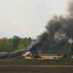 Shocking Train Tragedy: 32 Dead A train derailment scene with smoke rising from the wreckage