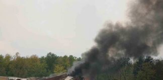 A train derailment scene with smoke rising from the wreckage