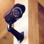 A security camera mounted on a wooden wall