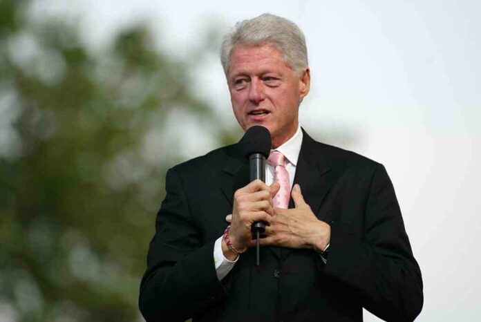 A man in a suit speaking into a microphone at an outdoor event
