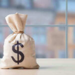 NEW Ukraine Tab: $588 Billion Nightmare Money bag with dollar sign on table.