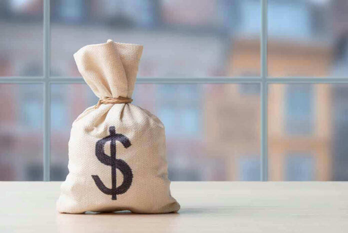 Money bag with dollar sign on table.