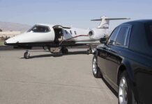 A private jet parked at an airport with a luxury car in the foreground