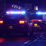 HORRIFYING School Massacre Plot STOPPED Police cars with flashing lights at a nighttime scene near a motel