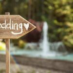 Wooden sign pointing towards a wedding venue