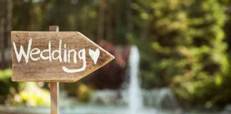 Wooden sign pointing towards a wedding venue