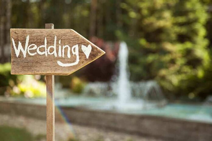 Wooden sign pointing towards a wedding venue