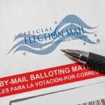 Official election mail envelope with a pen beside it