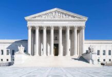 The Supreme Court building featuring marble columns and a clear blue sky