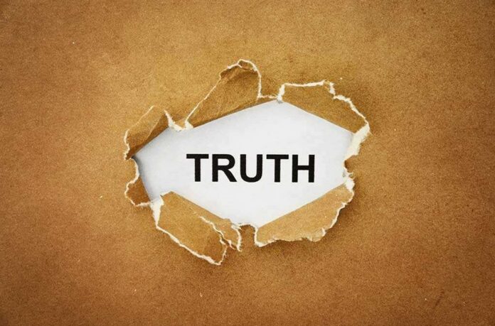 A piece of torn paper revealing the word TRUTH underneath