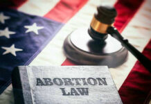 Abortion law book, gavel, and American flag.