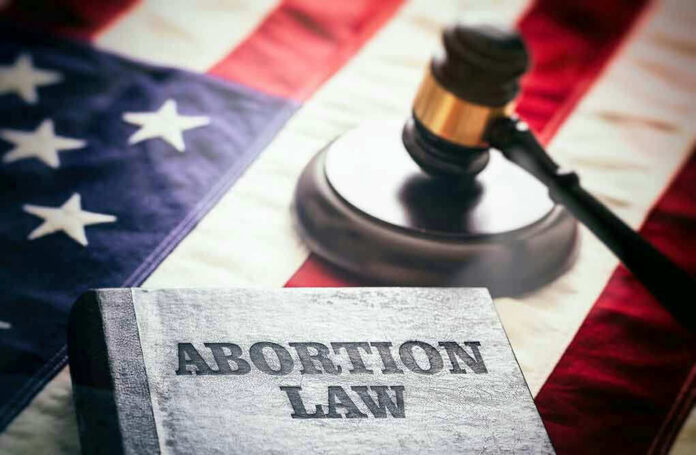 Abortion law book, gavel, and American flag.