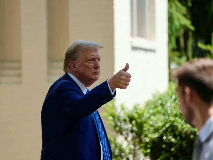 Man in suit giving thumbs up.