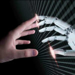 $100 Gripper Pulls Off Human Tricks Human and robotic hands almost touching fingers.