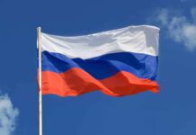 The flag of Russia waving against a clear blue sky