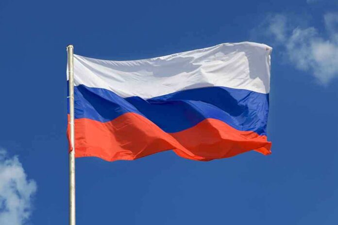 The flag of Russia waving against a clear blue sky
