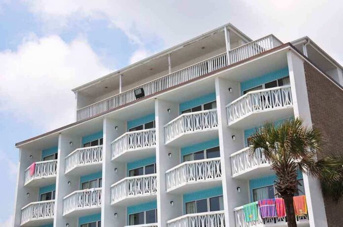Exterior view of a beachfront hotel with balconies and colorful towels hanging