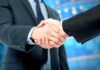 Two business professionals shaking hands in a corporate setting