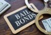 A bail bonds sign with handcuffs and stacks of cash