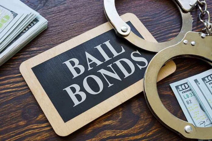 shutterstock_2025720947 (1).jpg A bail bonds sign with handcuffs and stacks of cash
