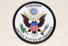 Seal of the United States Embassy featuring an eagle and the American flag