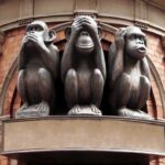 Three monkey sculptures representing see no evil, hear no evil, and speak no evil