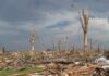 HORRIFYING Tornado Destroys Michigan Towns — Four DEAD A landscape showing destruction from a natural disaster with fallen trees and debris scattered across the ground