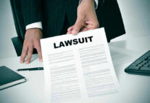 Person holding a document titled LAWSUIT in office.