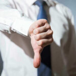 Person giving a thumbs down gesture.