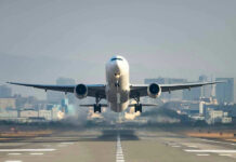 Airplane taking off from runway in urban area