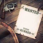 A vintage wanted poster alongside a revolver and rope on a wooden table