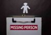 Clipboard with a missing person notice and a paper cutout figure