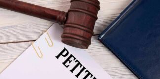 A gavel resting on a legal petition document with a pen and a folder