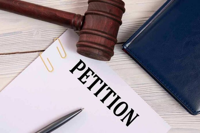 A gavel resting on a legal petition document with a pen and a folder