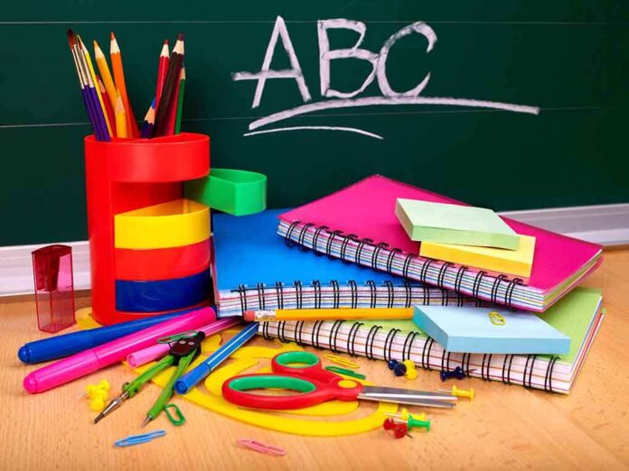 A collection of colorful school supplies including notebooks, pens, and scissors on a desk