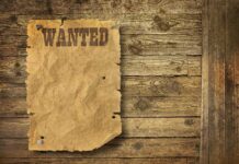 35,000 Names EXPOSED—“Start The Hunt” A vintage wanted poster pinned to a wooden wall