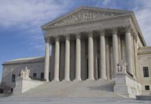 The Supreme Court building featuring large columns and statues