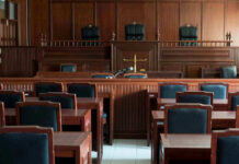 Empty courtroom with wooden furnishings and judges bench.
