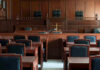 Empty courtroom with wooden furnishings and judges bench.