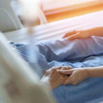 112 Hospice Providers Linked to One Address — Your Tax Dollars Hospital patient holding visitors hand reassuringly.