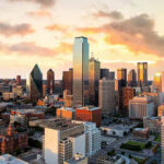 City skyline at sunset with modern skyscrapers.