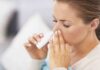 Woman applying nasal spray for relief