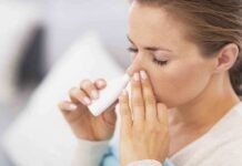 Woman applying nasal spray for relief