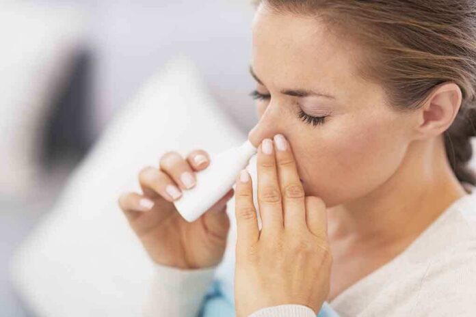 Woman applying nasal spray for relief