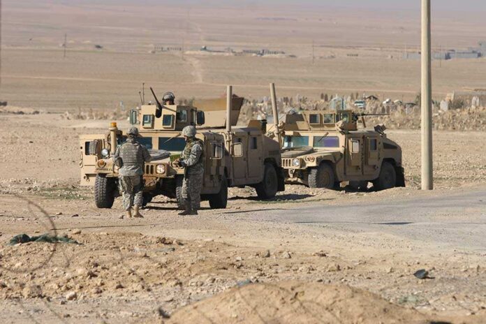Two military humvees with soldiers in a desert landscape