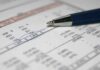 Close-up of a financial document with highlighted numbers and a pen